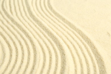 Photo of Zen rock garden. Wave pattern on beige sand