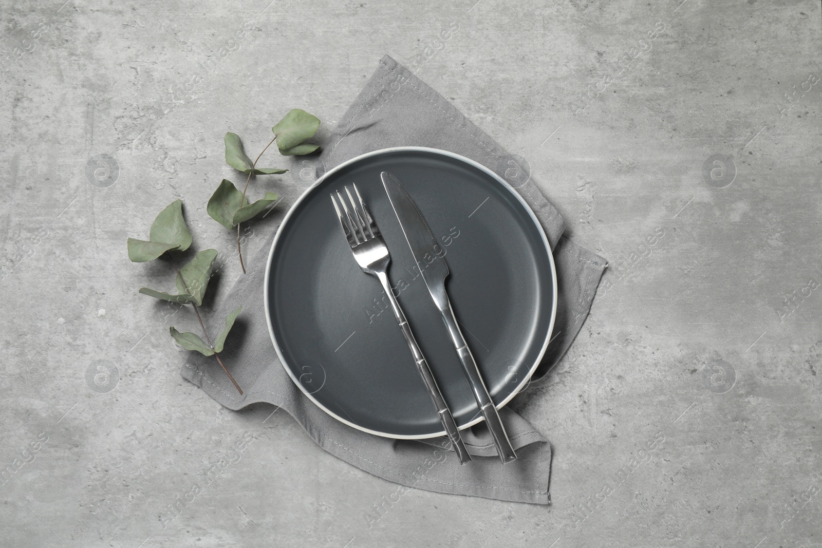 Photo of Stylish setting with elegant cutlery on grey table, top view