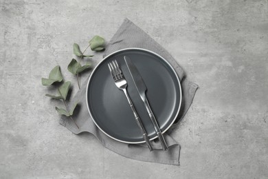 Stylish setting with elegant cutlery on grey table, top view