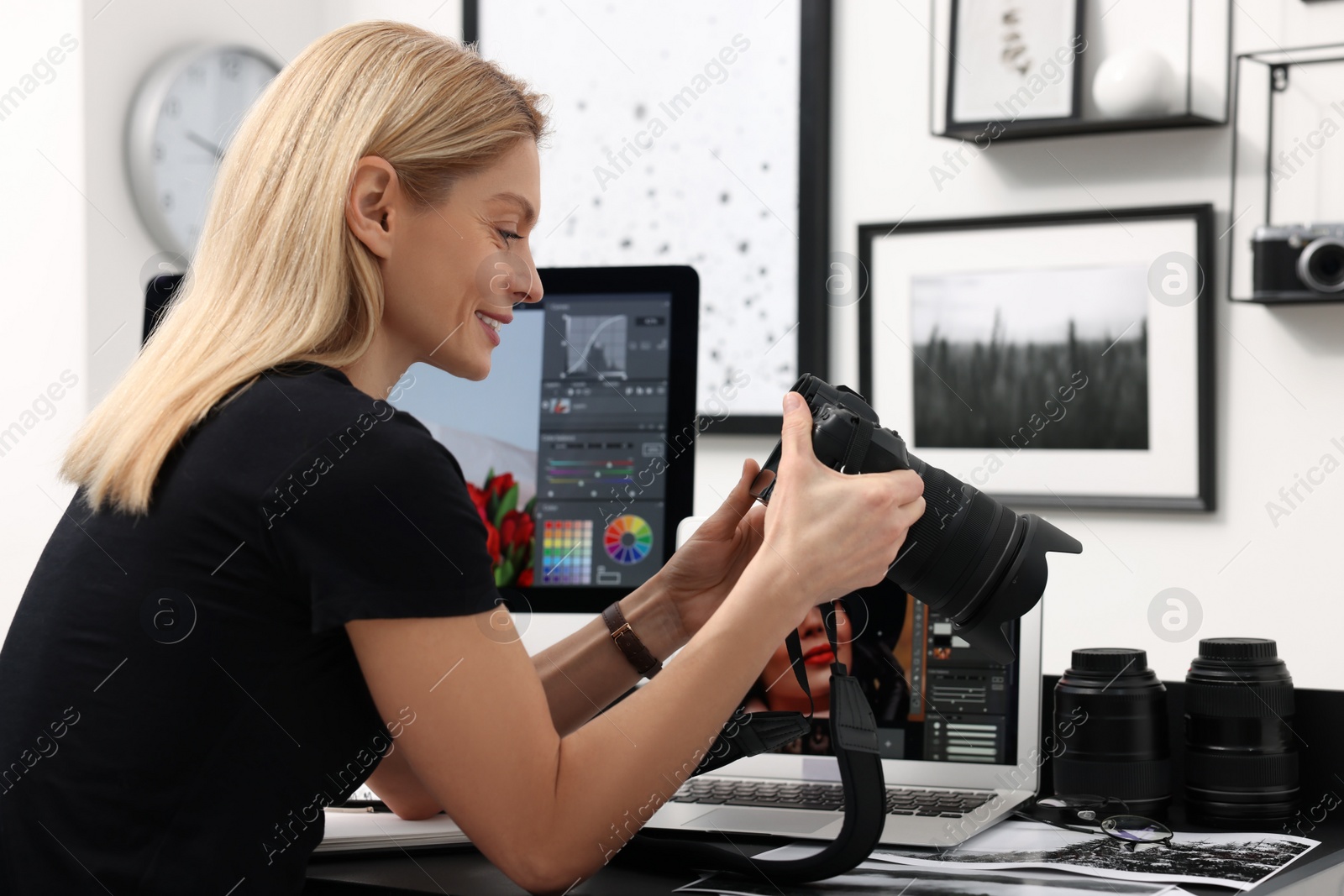 Photo of Professional photographer with digital camera at table in office