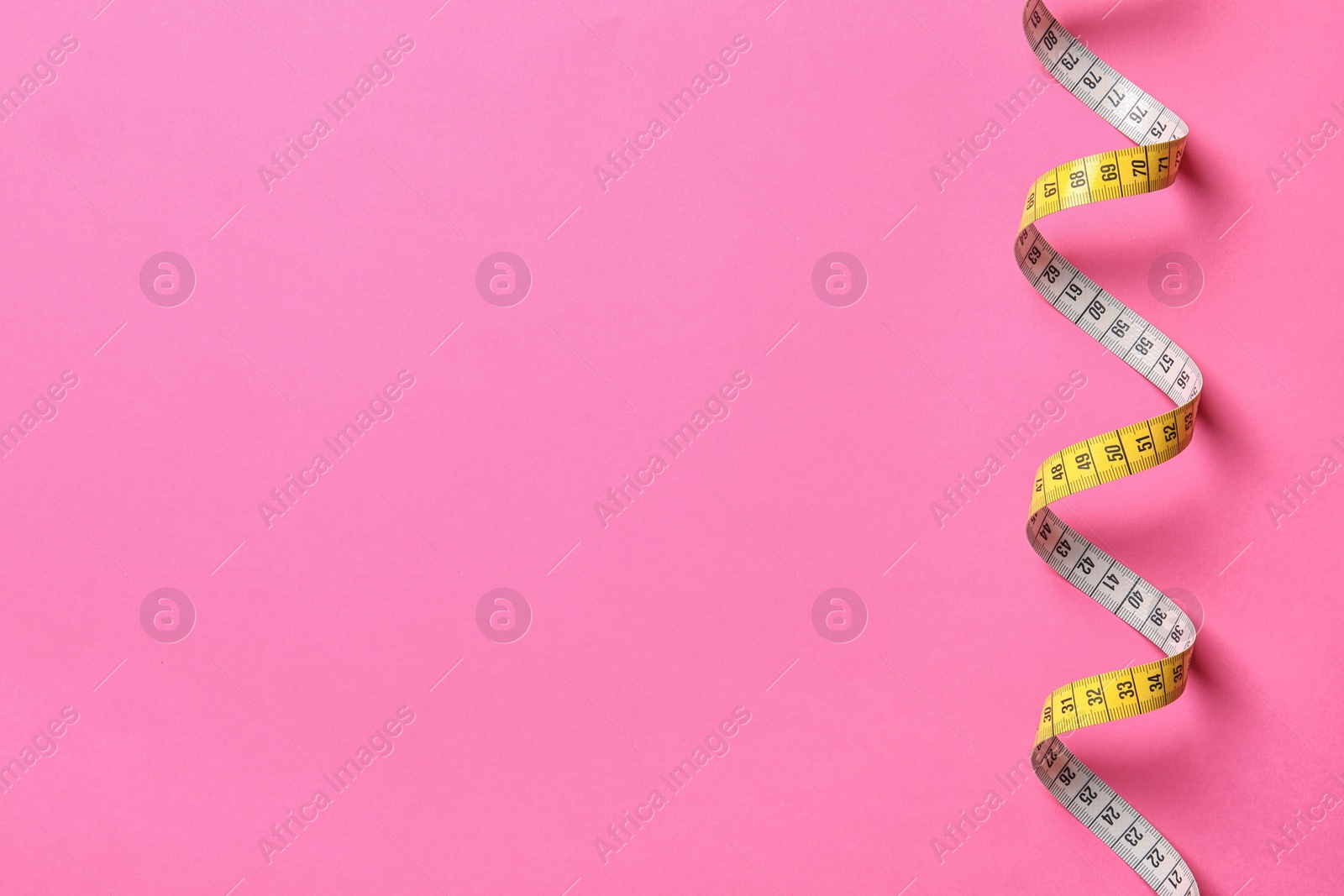 Photo of Measuring tape and space for text on color background, top view. Weight loss concept