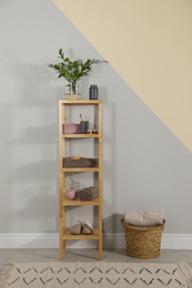 Photo of Shelving unit with toiletries near light wall indoors. Bathroom interior element