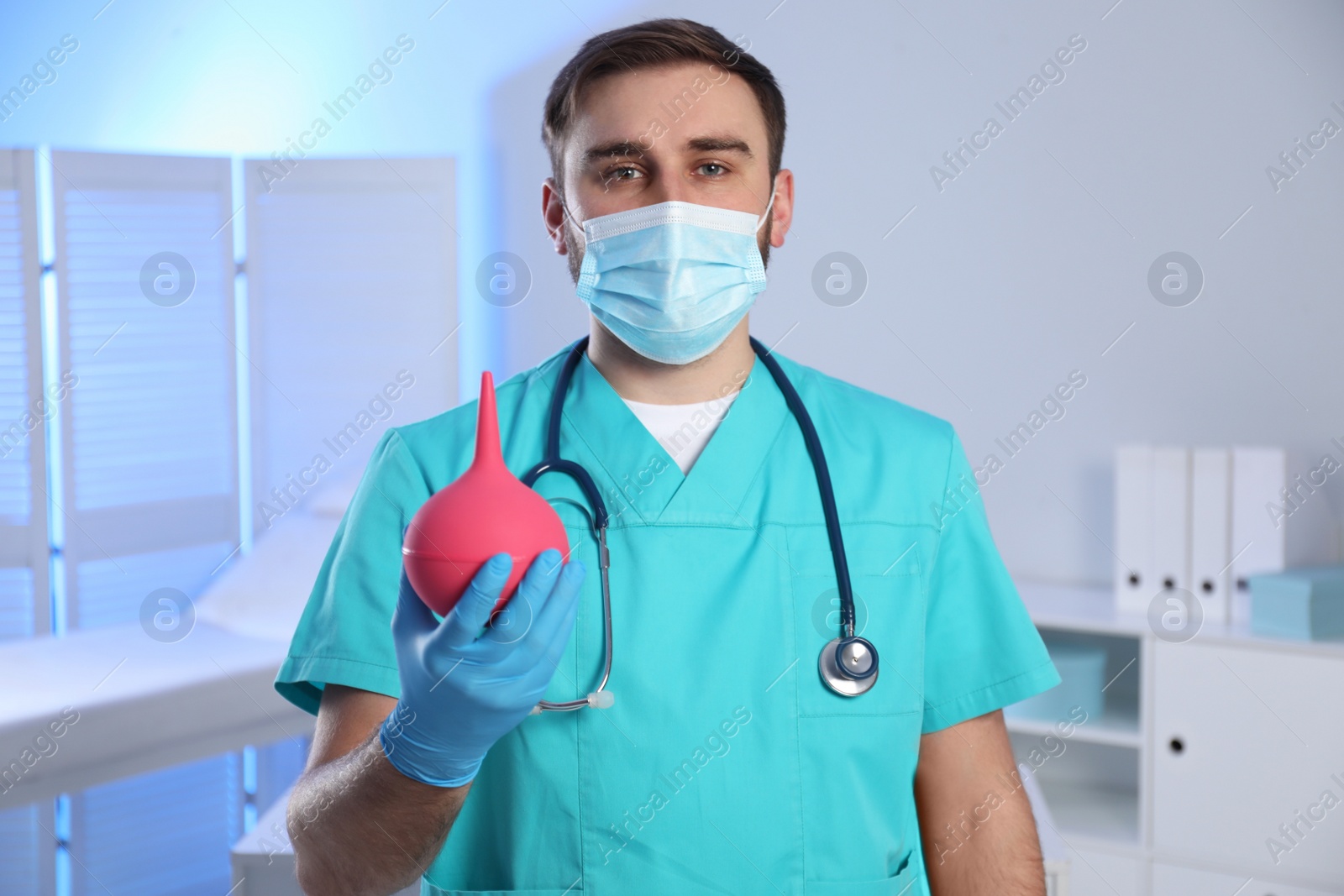 Photo of Doctor holding rubber enema in examination room