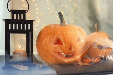 Halloween pumpkin heads. Jack lanterns on windowsill, view through glass