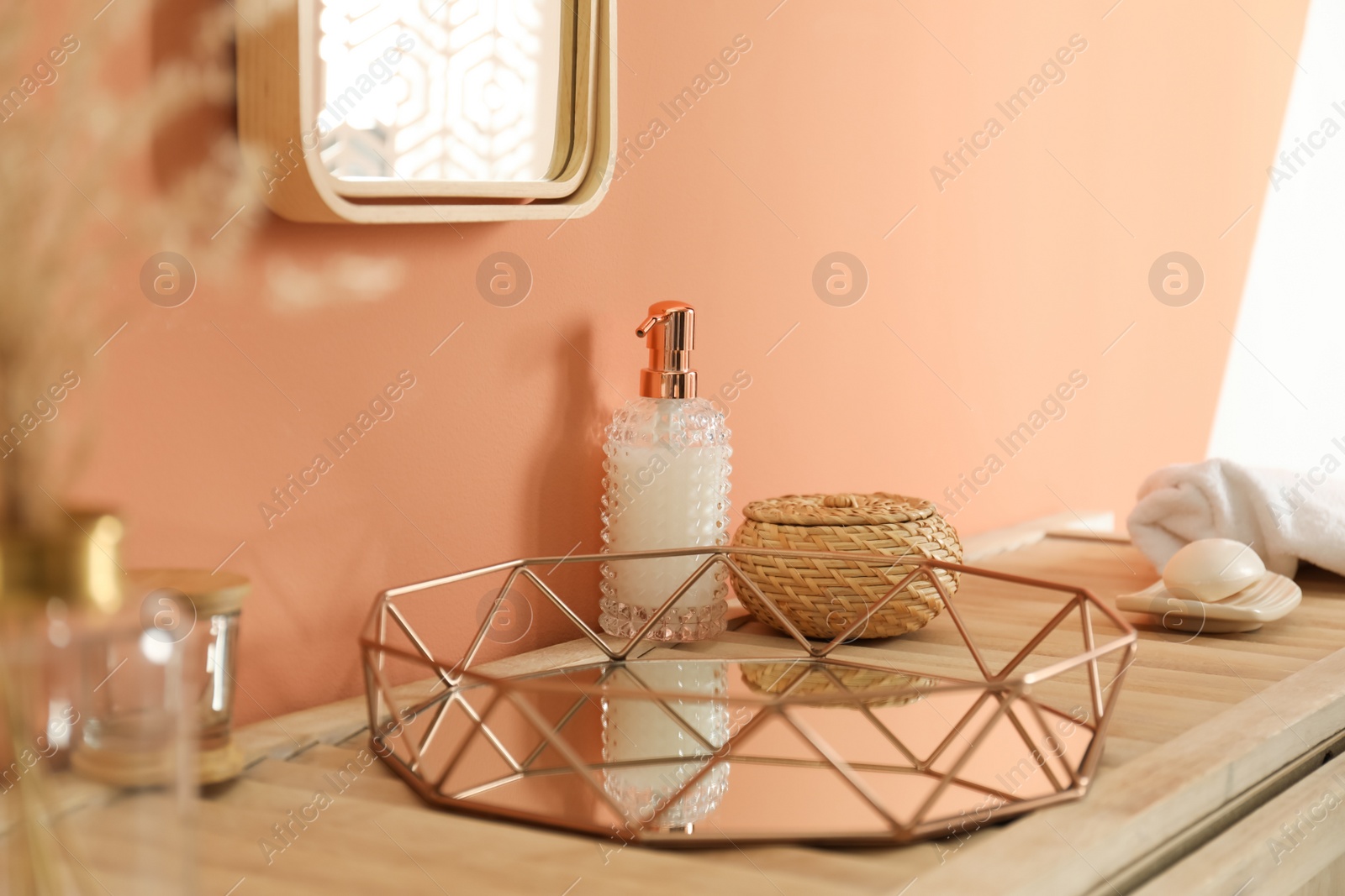 Photo of Soap dispenser and toiletries on wooden table indoors