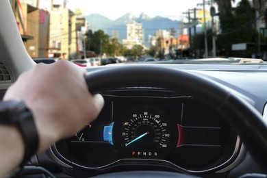 Image of Man driving modern car on city street, closeup