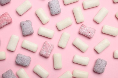 Different tasty colorful bubble gums on pink background, flat lay