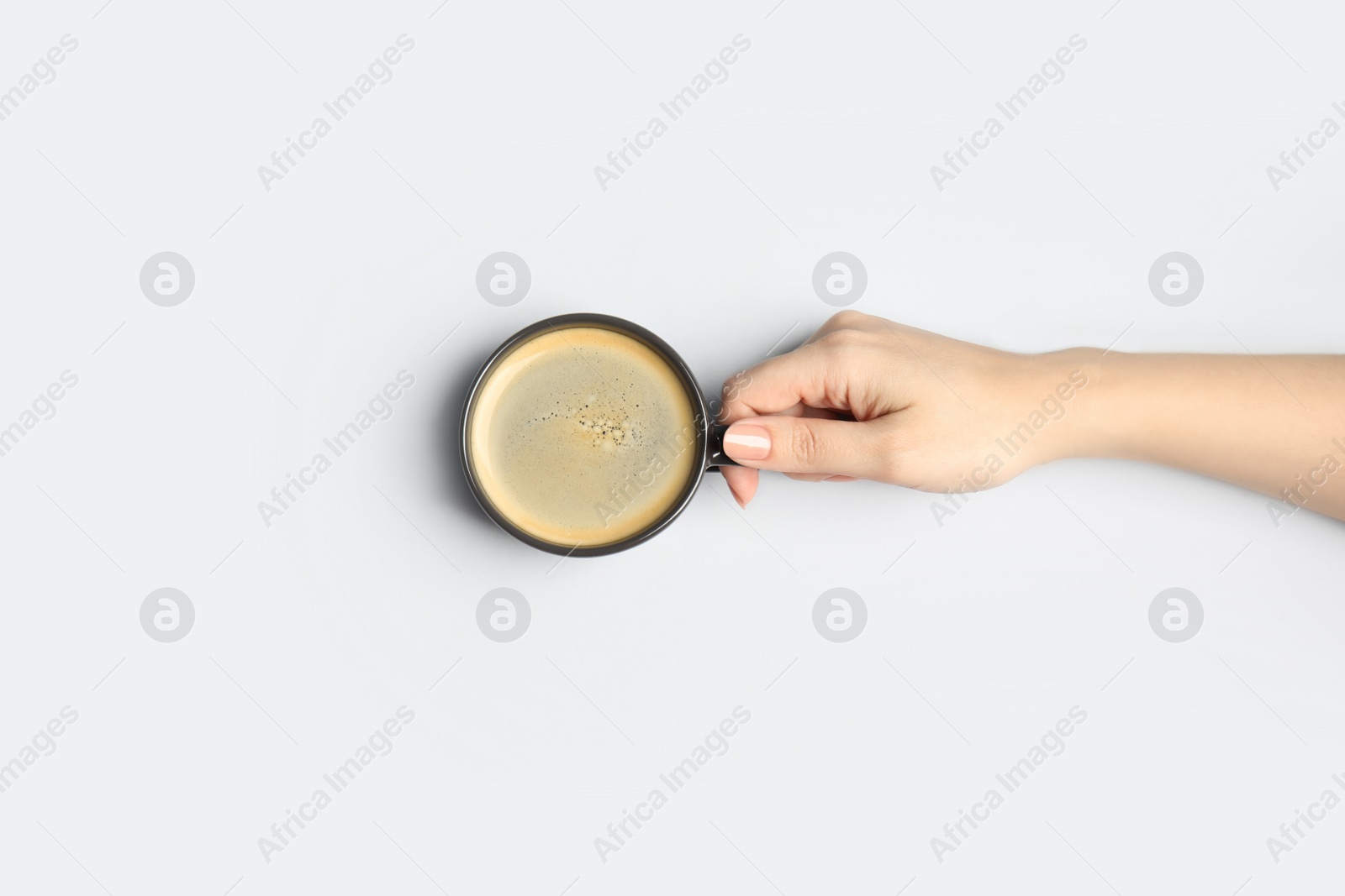 Photo of Woman with cup of coffee on light background, top view