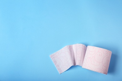 Photo of Roll of toilet paper on color background, top view. Space for text