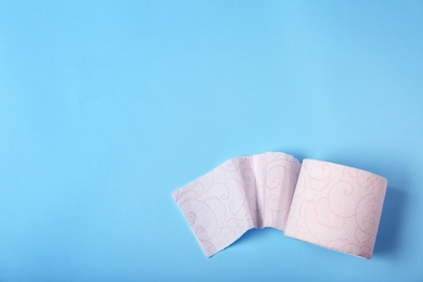 Roll of toilet paper on color background, top view. Space for text