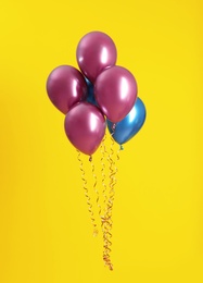Photo of Bunch of bright balloons on color background