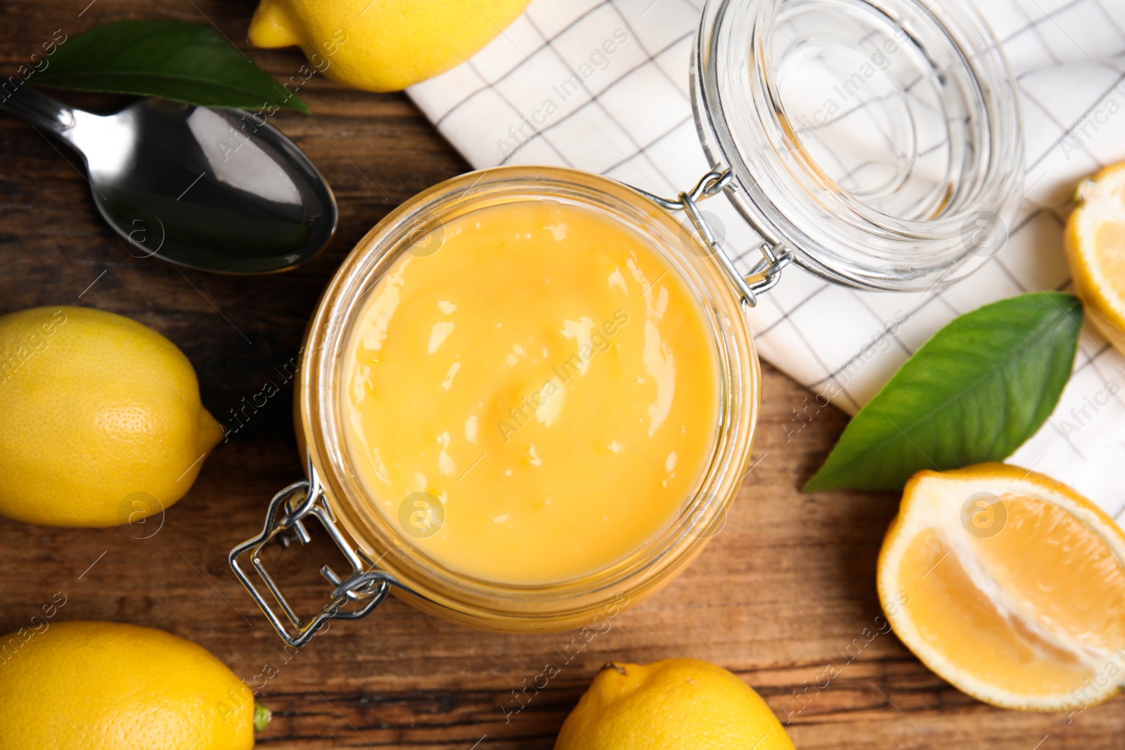 Photo of Delicious lemon curd and fresh fruits on wooden table, flat lay