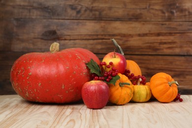 Photo of Happy Thanksgiving day. Pumpkins, apples and berries on wooden table