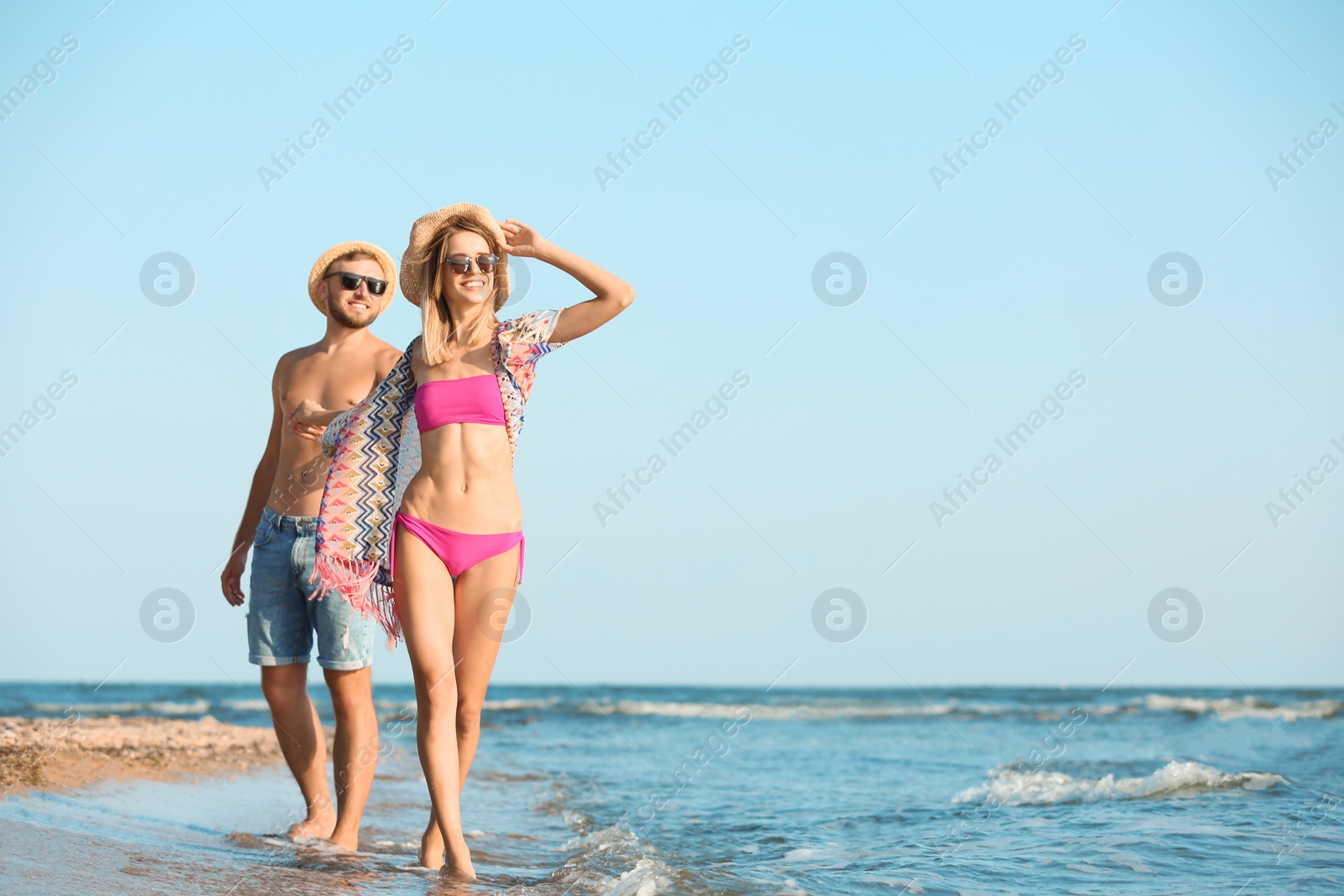 Photo of Young couple spending time together on beach