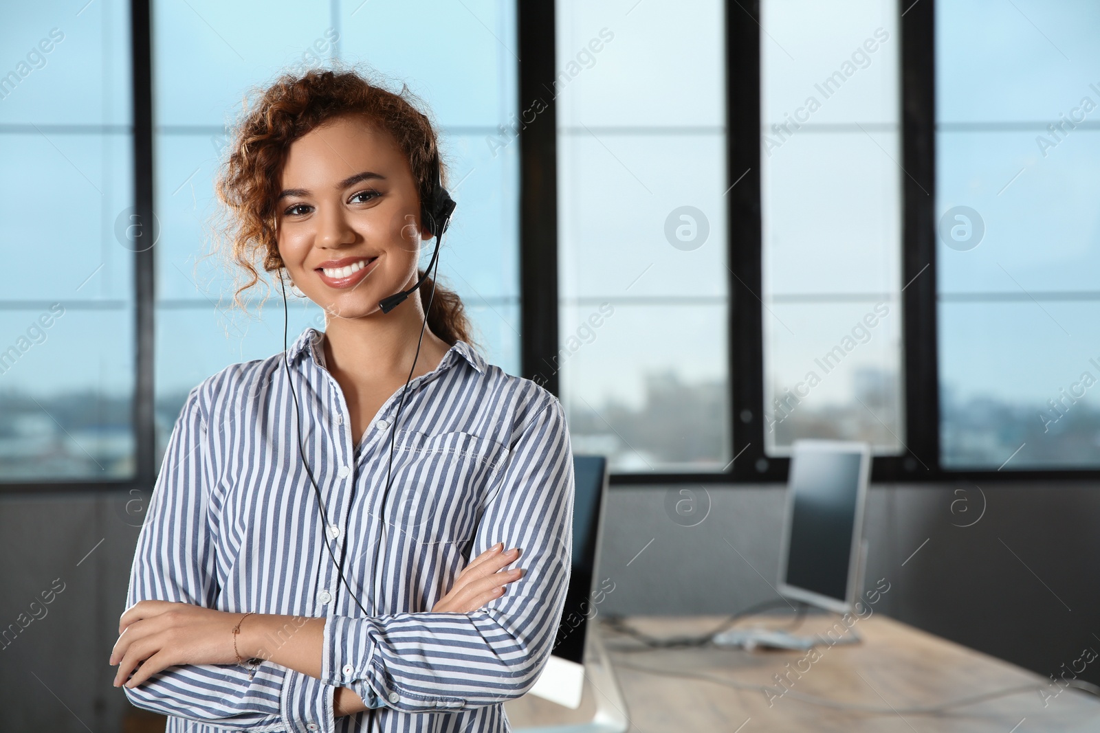 Photo of African-American technical support operator with headset in office. Space for text