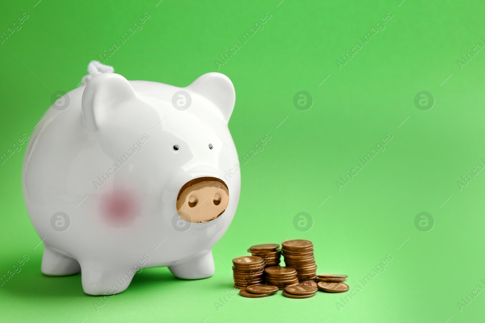 Photo of Piggy bank and coins on color background. Space for text