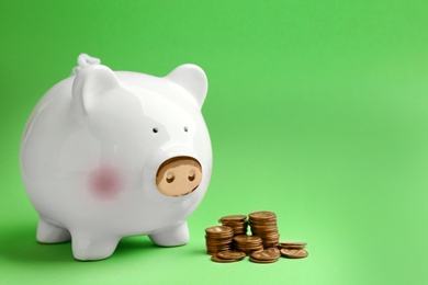 Piggy bank and coins on color background. Space for text