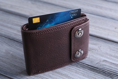 Photo of Credit card in leather wallet on grey wooden table, closeup