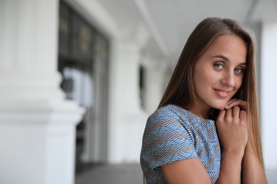 Beautiful young woman in stylish t-shirt indoors, space for text