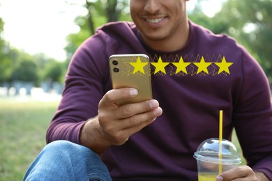 Man with smartphone giving feedback outdoors, closeup. Customer review