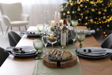 Christmas table setting with festive decor and dishware in room