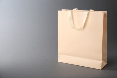 Photo of One paper bag on grey background, space for text. Mockup for design