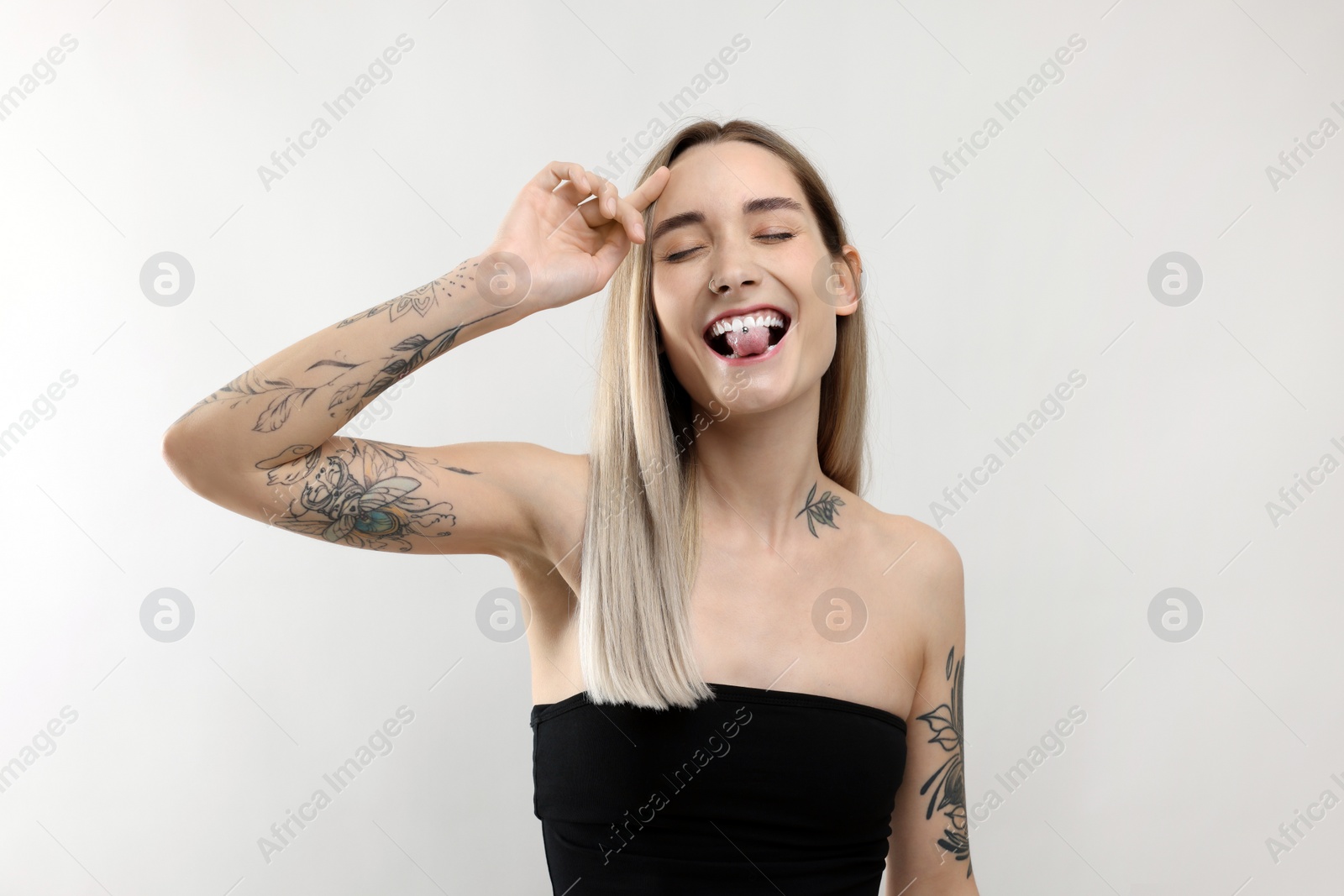 Photo of Portrait of beautiful tattooed woman on light background