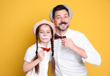 Dad and his daughter having fun on color background. Father's day celebration
