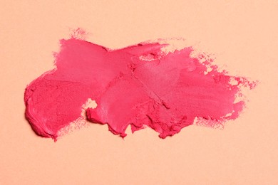 Photo of Smears of beautiful lipstick on beige background, top view