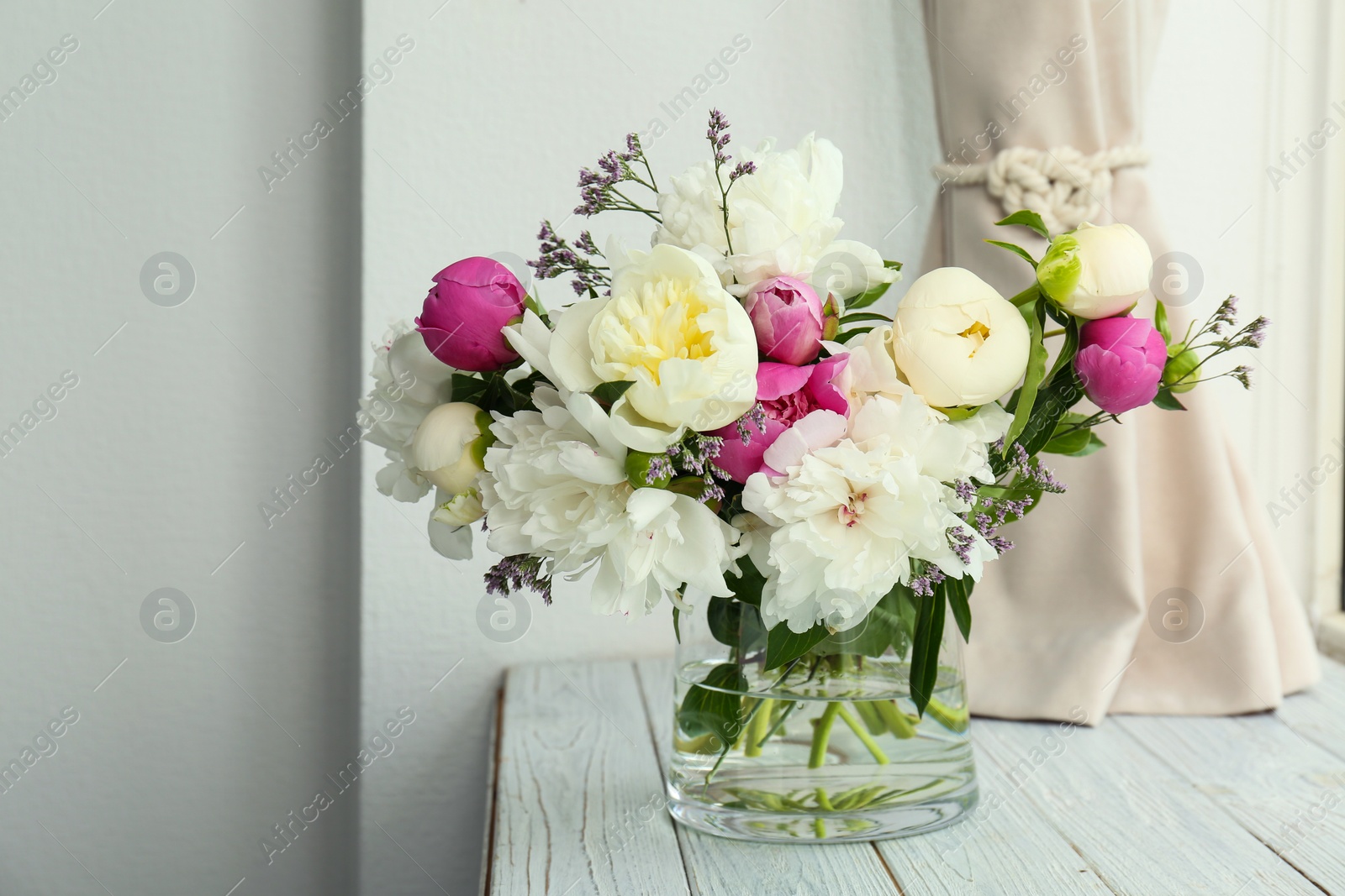 Photo of Vase with bouquet of beautiful flowers on wooden table