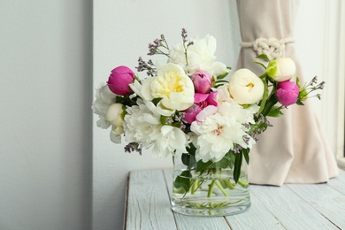 Photo of Vase with bouquet of beautiful flowers on wooden table