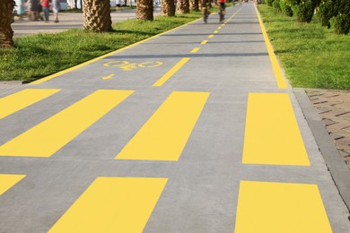 Photo of Bicycle lane with painted yellow sign and pedestrian crossing outdoors