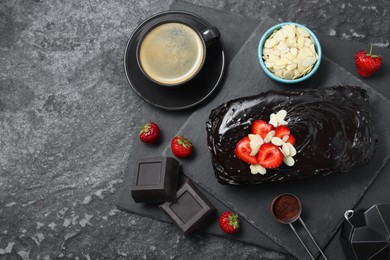 Photo of Delicious chocolate sponge cake, coffee and ingredients on black table, flat lay