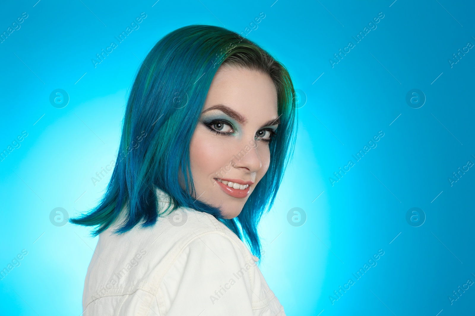 Photo of Young woman with bright dyed hair on light blue background