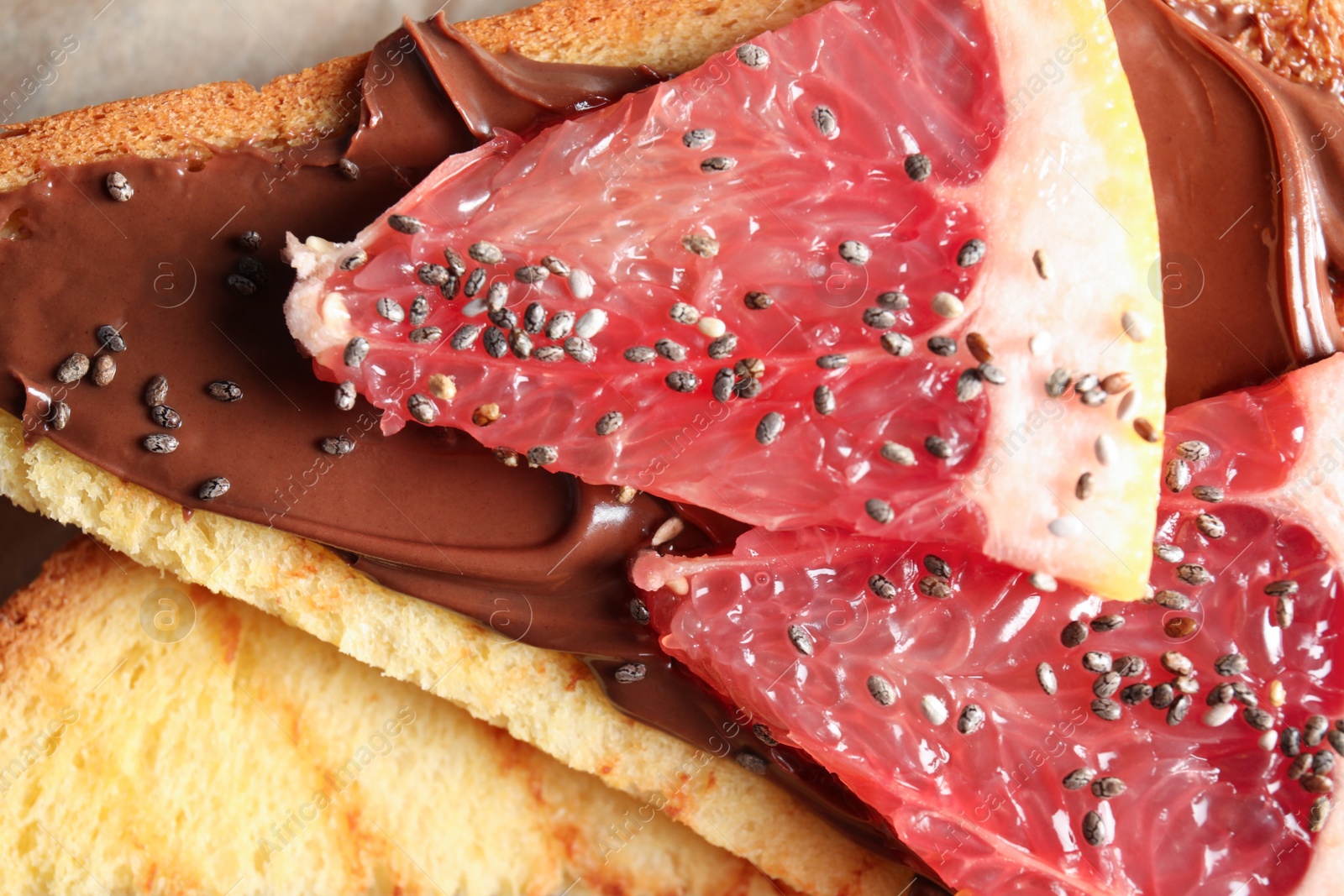 Photo of Tasty toast with grapefruit, chocolate paste and chia seeds, closeup
