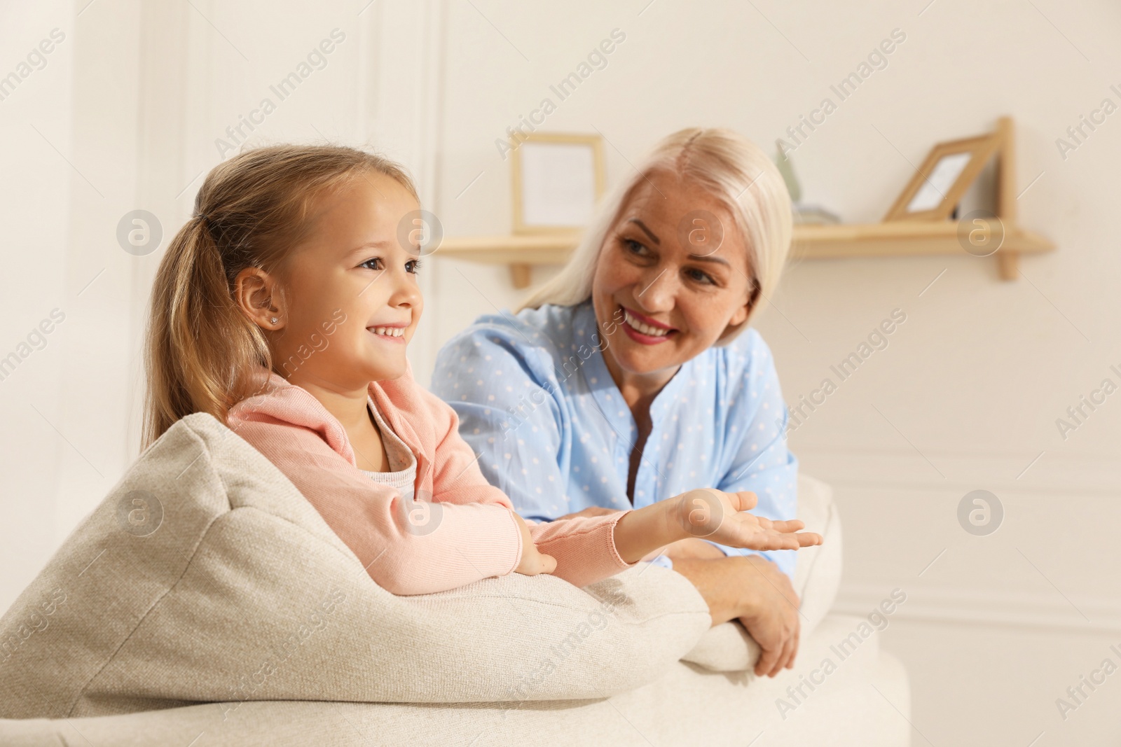 Photo of Happy grandmother spending time with her granddaughter at home