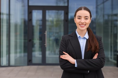 Photo of Happy real estate agent outdoors. Space for text