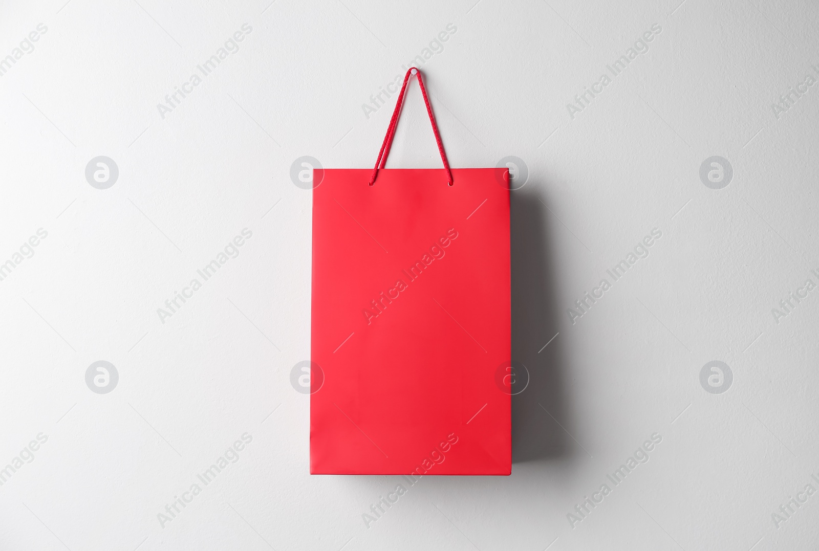 Photo of Paper shopping bag hanging on white wall