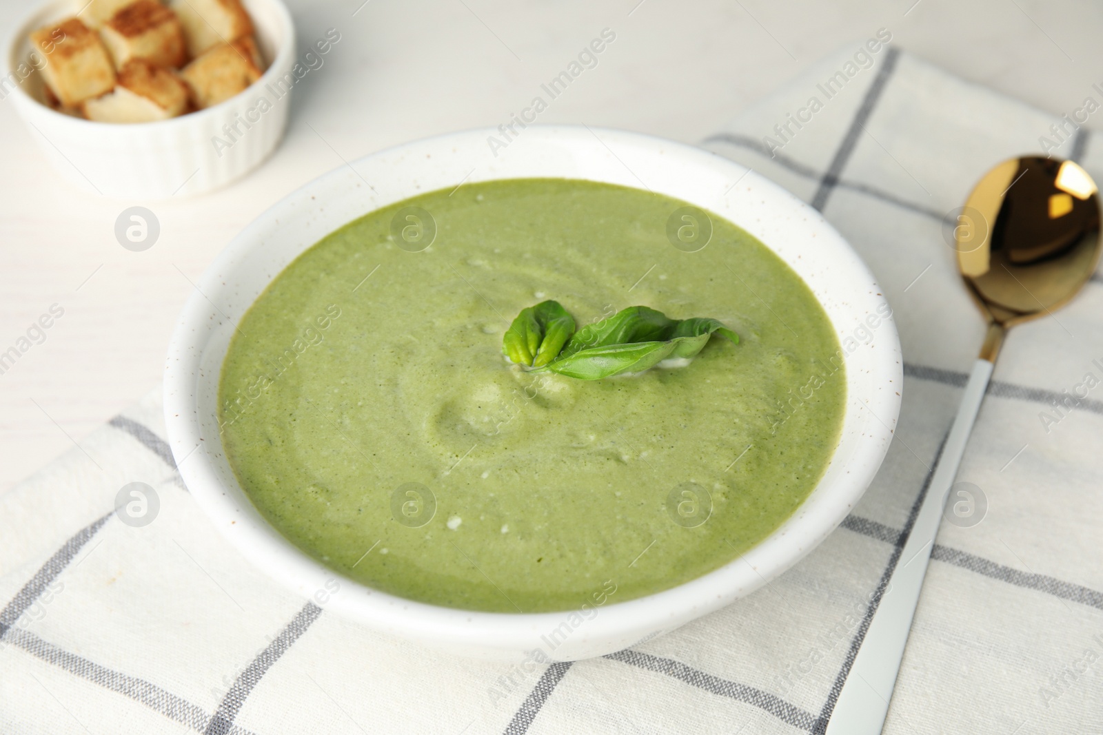 Photo of Delicious broccoli cream soup served on white table