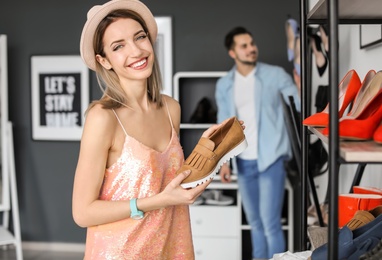 Young woman choosing shoes in store