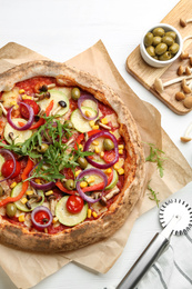 Flat lay composition with vegetable pizza on white wooden table