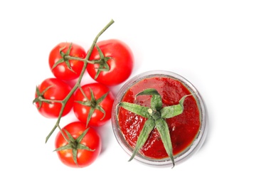 Tasty homemade tomato sauce in glass jar and fresh vegetables on white background, top view