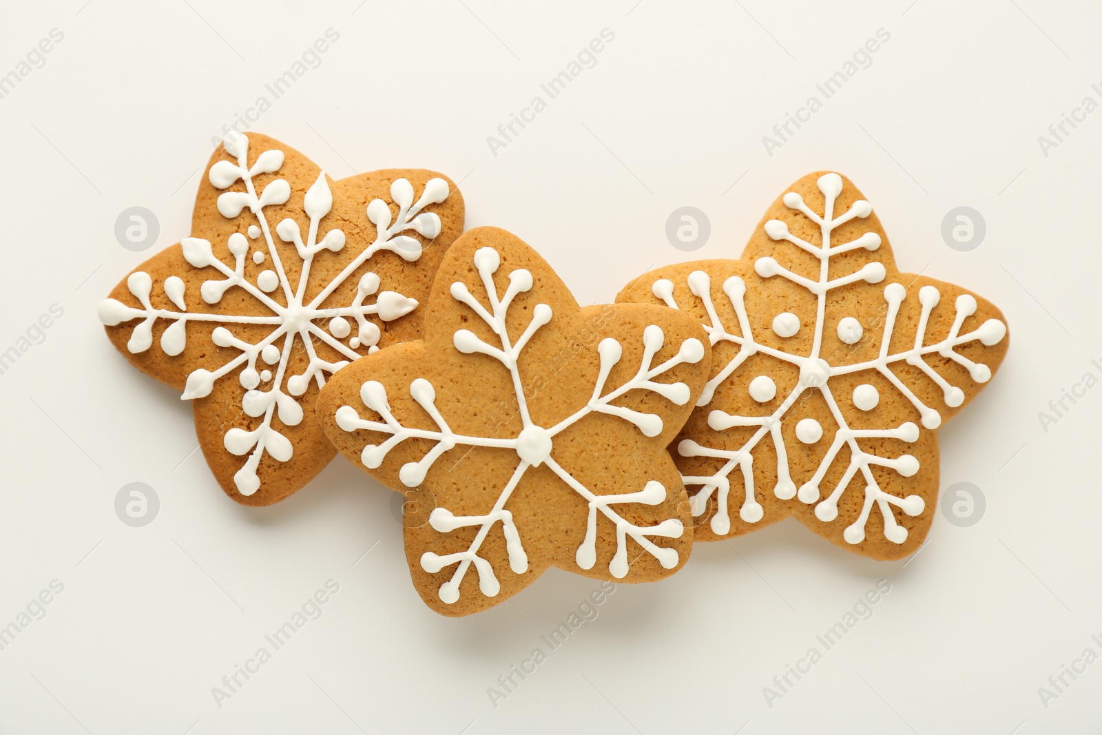 Photo of Tasty Christmas cookies with icing on white background, flat lay