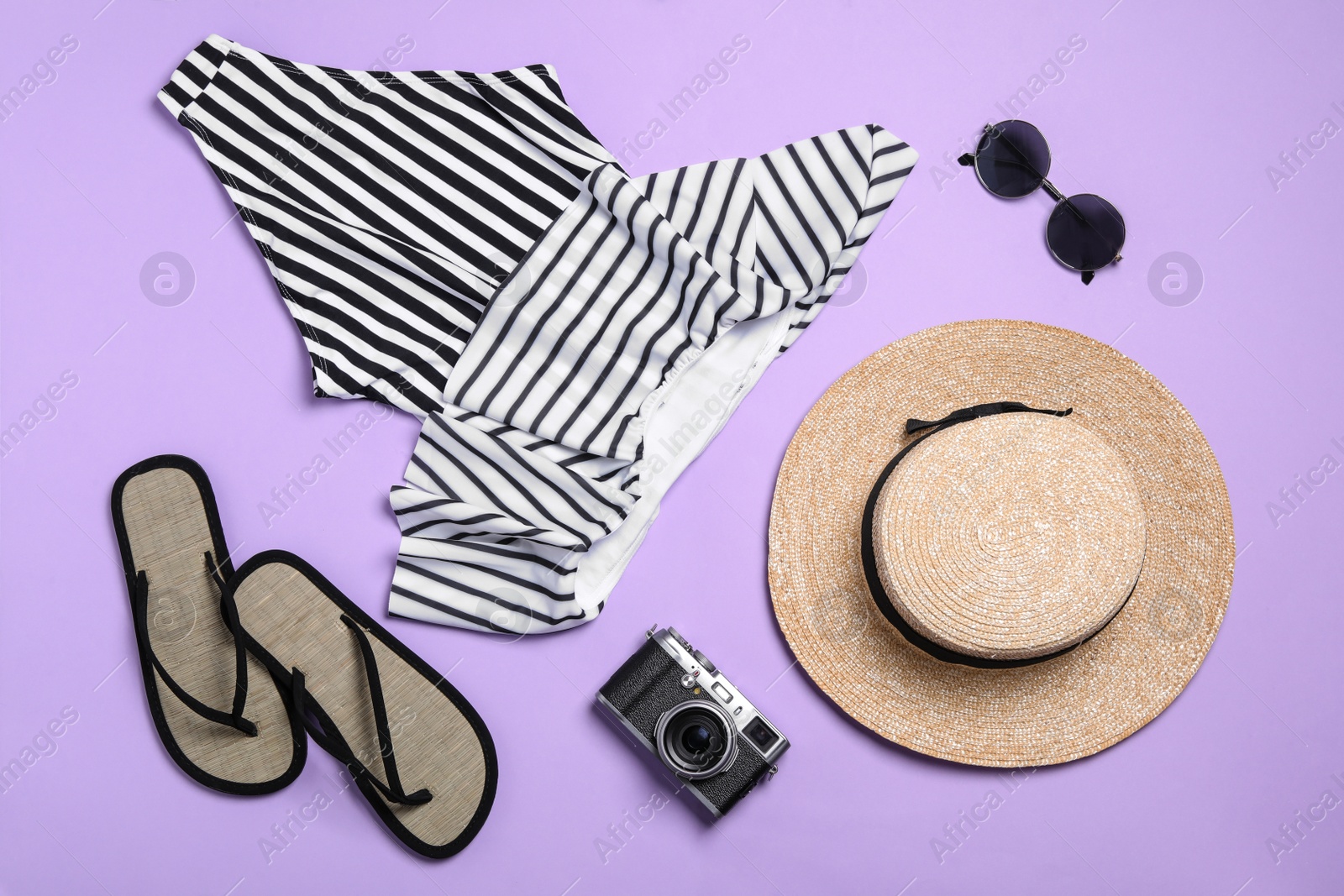 Photo of Flat lay composition with stylish beach accessories on lilac background