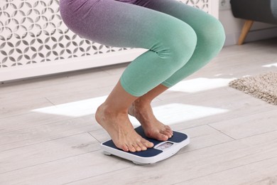 Photo of Woman on floor scale at home, closeup. Weight control