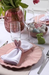 Photo of Festive table setting with napkin ring in shape of bunny ears. Easter celebration