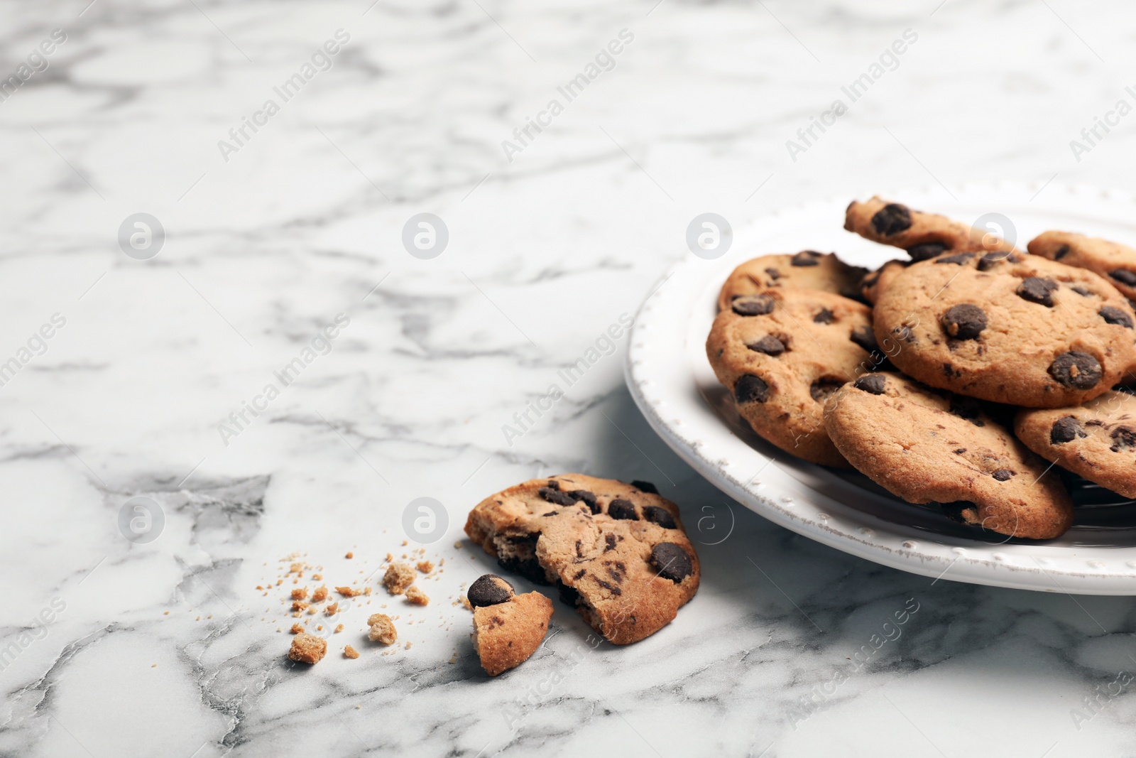 Photo of Plate with tasty chocolate cookies on marble table