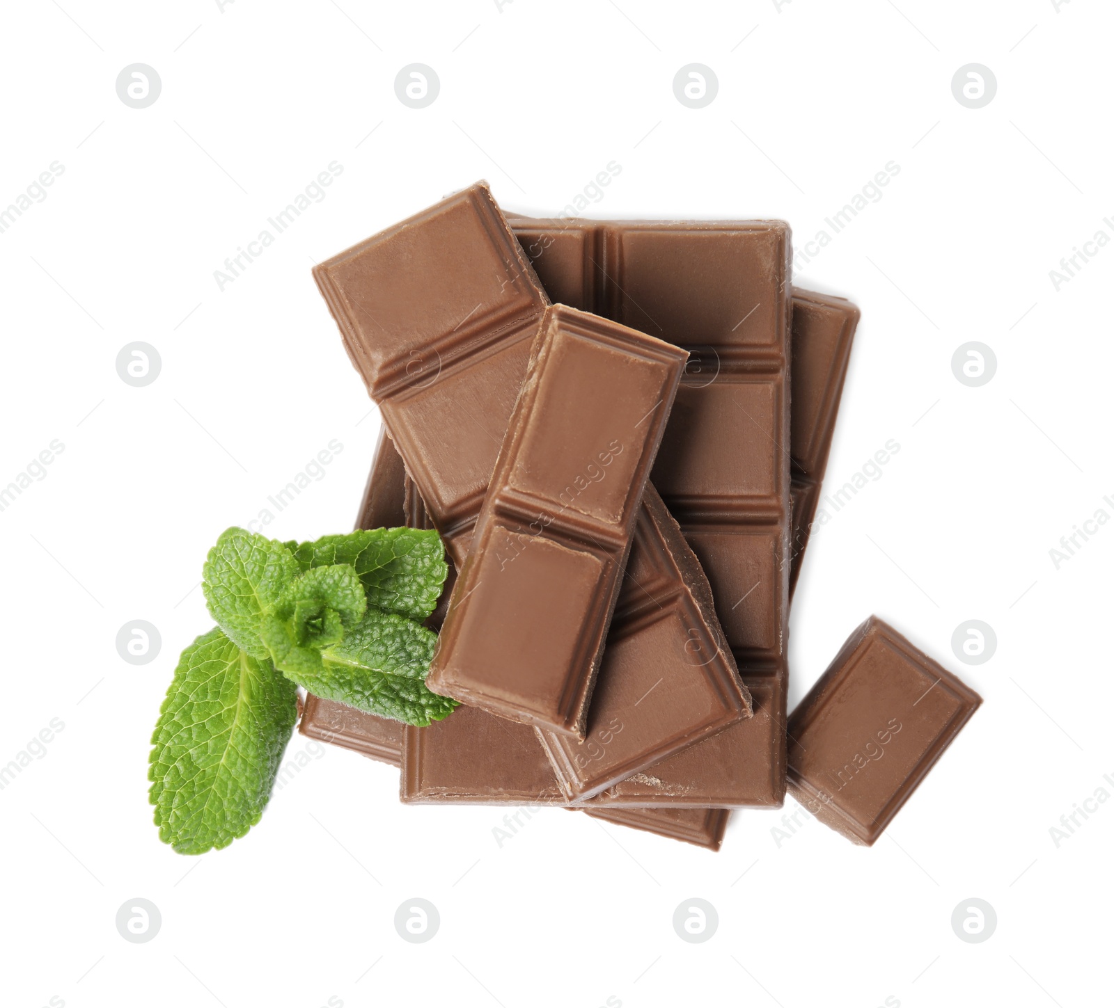 Photo of Tasty milk chocolate pieces with mint on white background, top view
