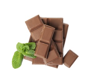 Tasty milk chocolate pieces with mint on white background, top view