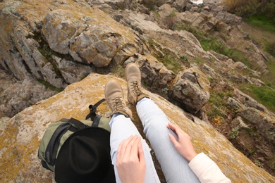 Photo of Woman with backpack on steep cliff, closeup